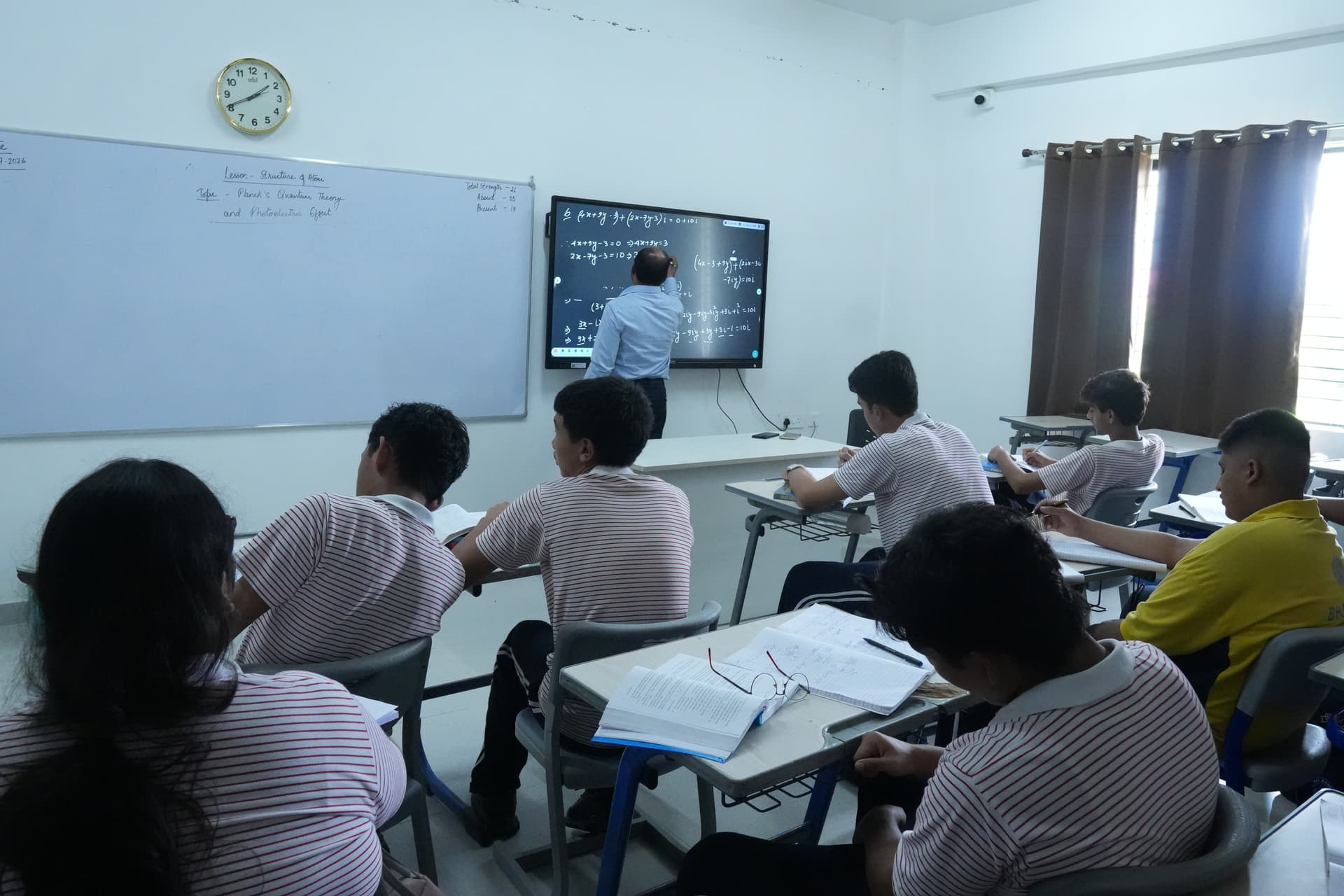 Students learning with a wall-mounted digital display at Sri Sri Academy